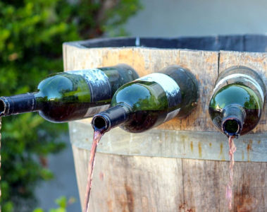 A wine fountain in Italy with wine coming out of bottles