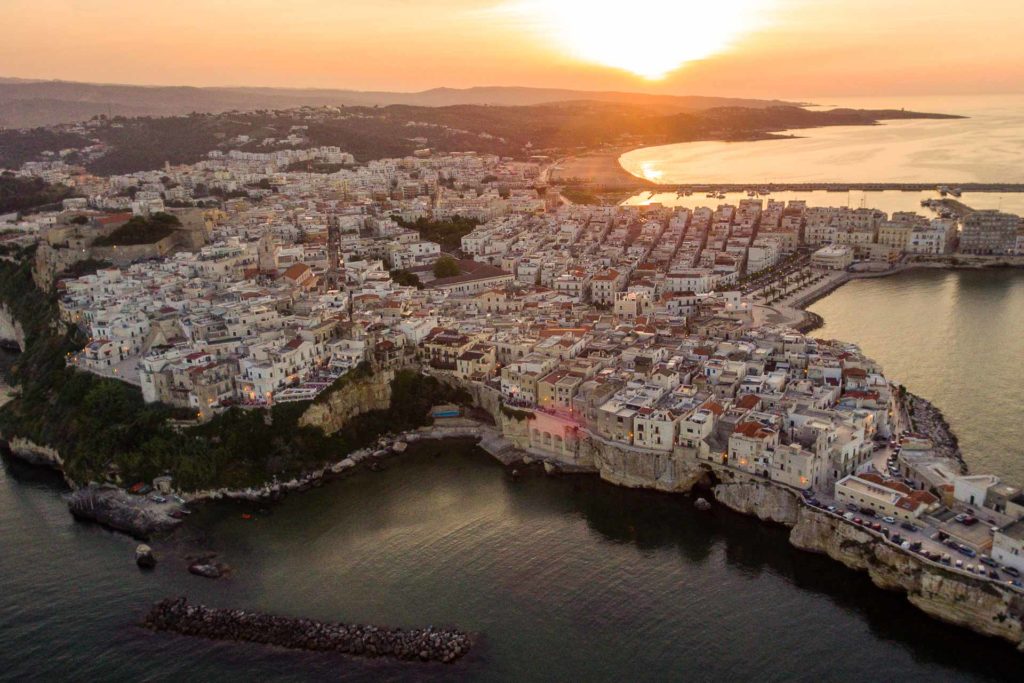 Vista aerea de Vieste na Puglia, rodeada pelo mar durante o por do sol