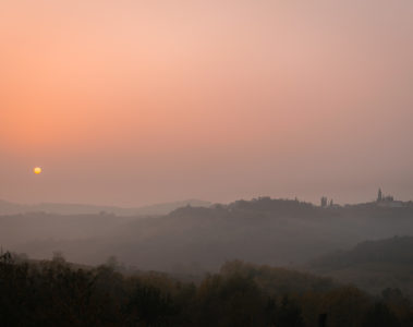 The sun setting in the horizon in a pinkish sky in Slovenia