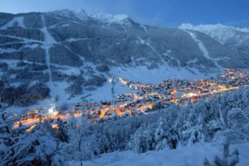 Aprica near Milan covered in snow with orange lights from the city near the ski slopes