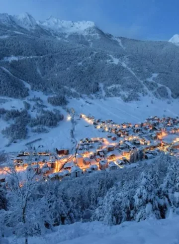 Aprica near Milan covered in snow with orange lights from the city near the ski slopes