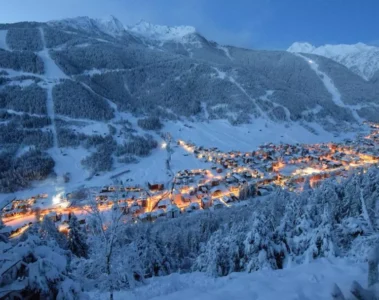 Aprica near Milan covered in snow with orange lights from the city near the ski slopes