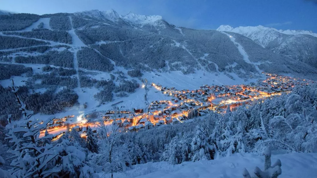 Aprica near Milan covered in snow with orange lights from the city near the ski slopes